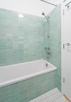 a white bath tub sitting next to a walk in shower under a faucet