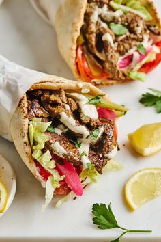 two pita sandwiches with meat, lettuce and tomatoes