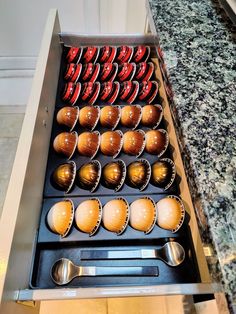 an open drawer filled with cups and spoons