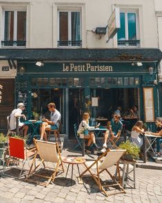 people sitting at tables in front of a restaurant