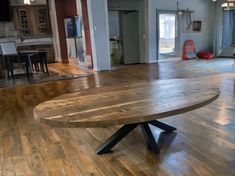 a large wooden table sitting on top of a hard wood flooring covered kitchen area