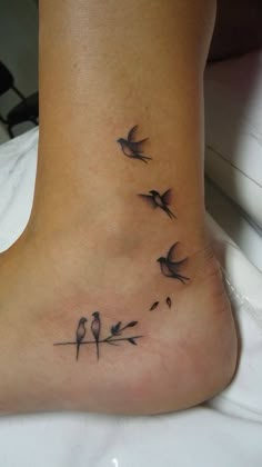 a small foot tattoo with birds on it