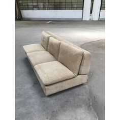 a beige couch sitting on top of a cement floor