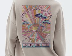 a man wearing a sweatshirt with an image of mushrooms on it and the words, enjoy the ride