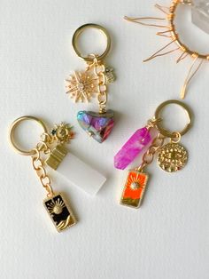 four key chains with charms on them sitting next to each other in front of a white background