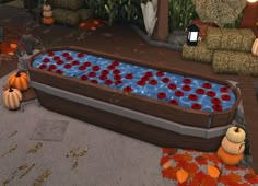 an inflatable hot tub with pumpkins on the ground and two small pumpkins sitting next to it