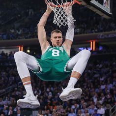 a basketball player in mid air after dunking the ball