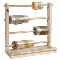 three rolls of tape are hanging on a wooden rack with two different colored spools