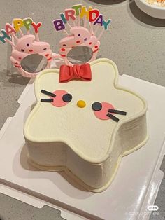 a birthday cake decorated like a cat with glasses on top