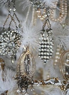 a chandelier with white feathers and beads hanging from it