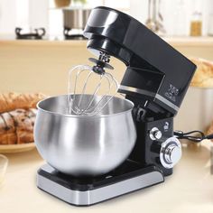 an electric mixer on a kitchen counter with pastries in the background