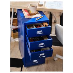 a blue file cabinet with three drawers and a coffee cup on the top one drawer