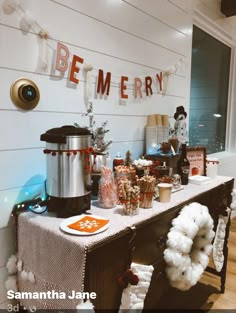 a table is set up for a party with decorations on it, and the words be merry spelled in red