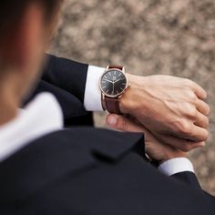 a close up of a person wearing a watch on his wrist and holding onto another man's hand