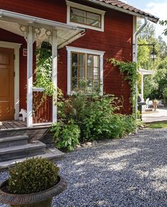 a red house with white trim on the front door and steps leading up to it