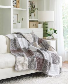 a living room with a white couch covered in a blanket