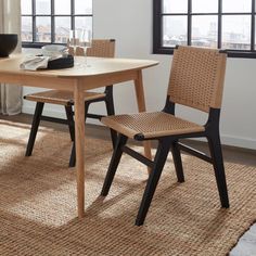 a dining table with two chairs and a bowl on the floor in front of it