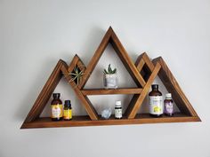 three wooden shelves with bottles and plants on them