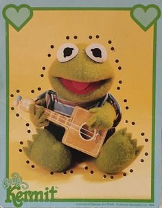 a green stuffed animal holding a ukulele