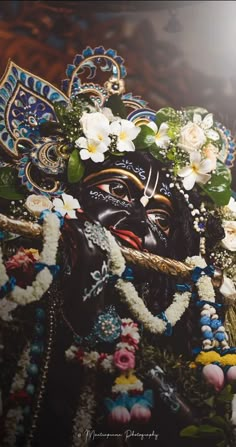 an idol is adorned with flowers and leaves