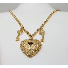 1980s goldtone pave round clear rhinestone heart with lock cut out center pendant with two goldtone key charms on either side necklace with lobster clasp. Marked "Napier" in script on a cartouche near the clasp and "©Napier" in script on the back of the pendant. Heart pendant measures: 1 1/8 inches long by 1 inch wide. Chain doubled measures: 15 1/4 inches long. Condition: Very good; perhaps a little bit of yellowing to a few rhinestones but nothing very noticeable. Gold Heart Necklace With Two Keys, Lock Pendant, Key Charms, Heart Lock, Pendant Heart, Rhinestone Heart, Clear Rhinestones, Vintage Signs, Heart Pendant