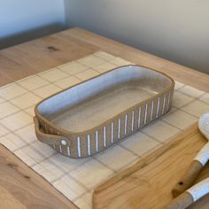 a wooden cutting board topped with a loaf of bread next to a knife and spatula