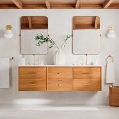 a bathroom with two sinks and mirrors on the wall