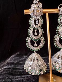 Gorgeous Handmade Statement Long Earrings in American Diamond in Sliver Color with Green Stones on all the corners and a hanging Pearl. Light Weight with back support. Item : Earring Set Color : Sliver and GreenLength of Earrings : 3.5 inches Width of Earnings - 1 inches (widest part)Circumference of the Jumka on the bottom - 4 inches Shop Polices -- Final Sale, No Return, No exchange - Please note Jewelry is delicate and Fragile, please handle with care.- There can be little variation in the co Silver Fusion Dangle Hoop Earrings, Festive Sterling Silver Single Earring, Silver Latkans Jewelry For Formal Occasions, White Gold Hand Set Earrings For Party, Formal Silver Jewelry With Latkans, Fusion Style Dangle Earrings For Party, Fusion Style Hand-set Chandelier Earrings, Fusion Dangle Earrings For Party, Silver Fusion Chandelier Earrings