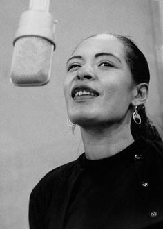 a black and white photo of a woman in front of a jar with something on it