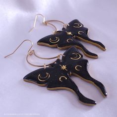 Subtle holographic shimmer accentuates the black polymer clay; gold moons are encased in resin to give strength, shine, and a professional finishing touch. These earrings are sure to make a statement and leave an impression! They measure just under 3 inches long and about 2 inches wide, hang from stainless steel crescent moons and French ear hooks. They are a medium weight, so I do not recommend them for novice earring wearers. The earrings are tough, but I do not recommend wearing in the shower Adjustable Black Crescent Earrings, Black Celestial Earrings For Gift, Handmade Magical Black Jewelry, Handmade Black Magical Jewelry, Handmade Black Crescent Earrings, Black Moon-shaped Earrings For Gift, Black Moon Shaped Earrings For Gift, Handmade Black Moon-shaped Earrings, Handmade Black Moon Earrings