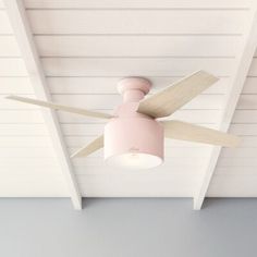 a pink ceiling fan mounted on the side of a white wall with wooden planks