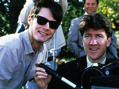 two men in suits and sunglasses sitting next to each other