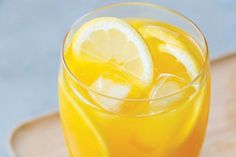 a glass filled with lemonade sitting on top of a table