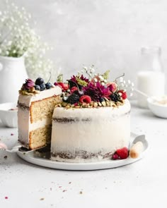 a cake with white frosting and berries on top