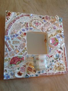 a decorative mirror sitting on top of a wooden table