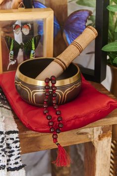 a wooden table topped with a bowl filled with beads