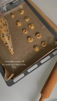 a cookie sheet with chocolate chip cookies on it and a wooden spatula next to it