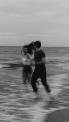 black and white photograph of two people in the ocean with one person holding his head