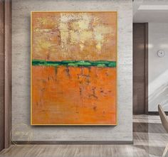 an orange and green painting hangs on the wall next to a dining room table with chairs