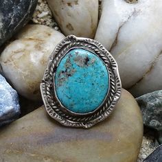 This is a Vintage Navajo Handmade Rustic Turquoise Pinky Ring SMALL SIZE 4 Stamp Decorated Sterling. This wonderful handcrafted rustic piece features a large beautiful turquoise stone with dark matrix and quartz surrounded by rope twist wire and an edged stamped back plate. The shank is cold chisel split. The ring is a SMALL SIZE 4 and is suitable as a pinky ring or small finger. Condition: vintage Size: 4 Metal: 925 Sterling Silver (tested) Surface: vintage patina Measurement: 1 1/8 x 1 inches Handmade Turquoise Ring, Cold Chisel, Silver Squash Blossom Necklace, Turquoise Statement Ring, Rope Twist, Turquoise Cuff, Silver Work, Vintage Navajo, Back Plate