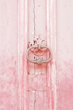 a pink door with a metal handle on it