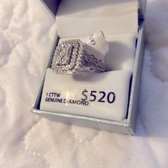 a diamond ring in a box on top of a white bed sheet with the price label below it