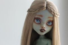 a doll with long blonde hair has blue eyes and brown lips on it's face