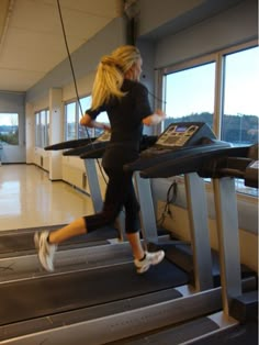 a woman running on a treadmill in a gym