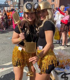 two women dressed in gold and black are posing for the camera with their arms around each other