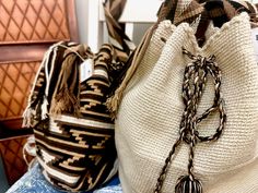 two woven bags sitting on top of a blue tablecloth covered chair next to each other