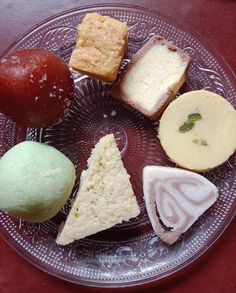 a glass plate topped with different types of desserts on top of a red table