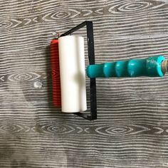 two toothbrushes are hanging on the wall next to a brush holder that is attached to a wood plank