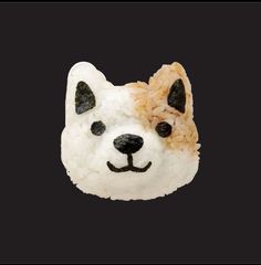 a white dog made out of rice with black spots on it's eyes and nose