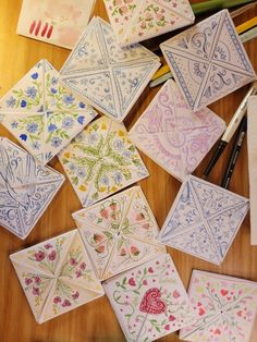 many different colored tiles on a table with markers and pencils next to them,